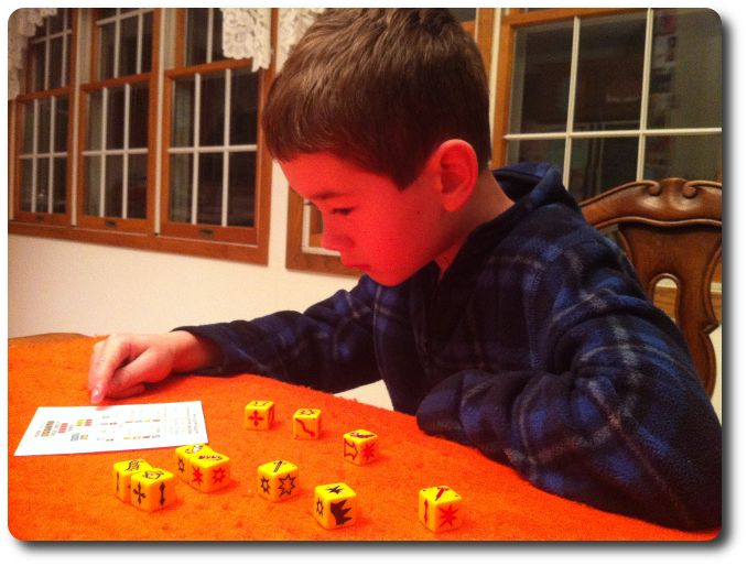 My little geek reviews his dice using the player aid sheet