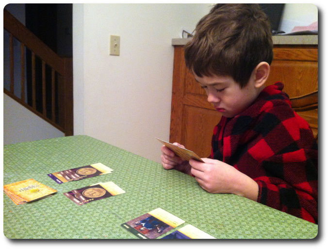 My little geek reviews his cards before making his play