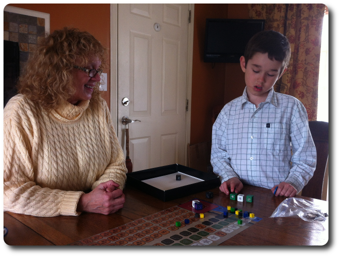 My little geeks considers which dice to roll as his Nana looks on affectionately  